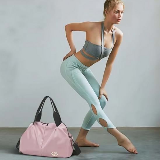 Sac de sport rose posée côté jeune gymnaste salle de sport